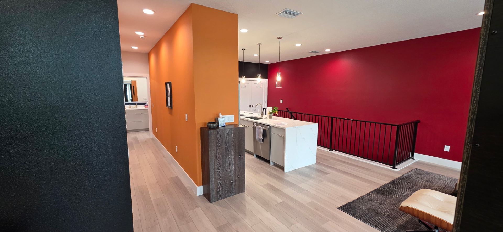 Open-concept interior with orange, deep red, and charcoal accent walls freshly painted